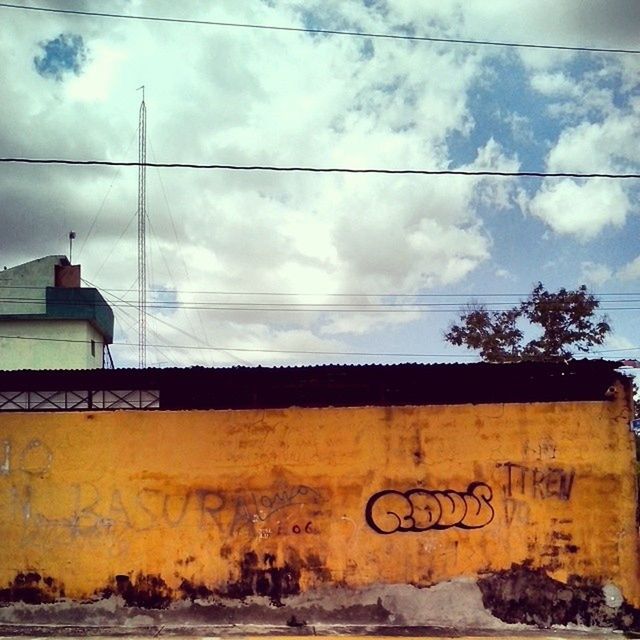 sky, power line, cloud - sky, electricity pylon, cable, cloud, cloudy, built structure, text, architecture, communication, power supply, western script, low angle view, electricity, building exterior, connection, no people, outdoors, power cable