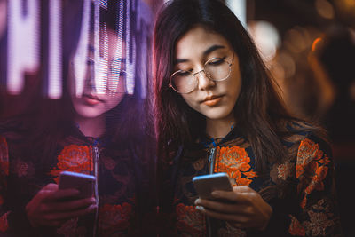 Young woman using mobile phone at home