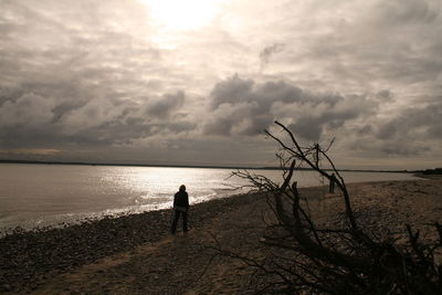 Silhouette person standing on beach against sky hiddensee 