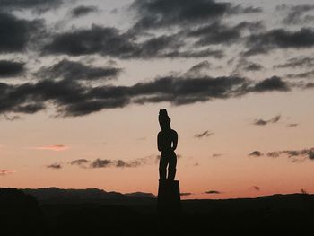 Silhouette statue against sky during sunset