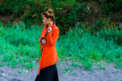 Young woman standing by plants