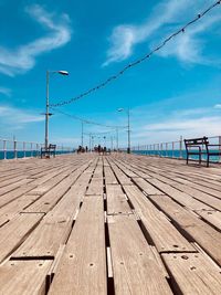 Surface level of pier on beach against sky