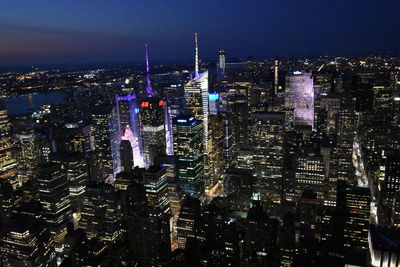 Illuminated cityscape against sky at night