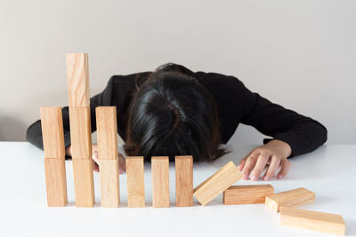 Businesswoman resting by dominoes at table