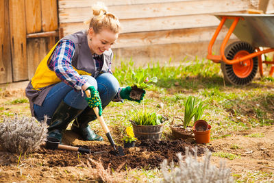 Full length of woman gardening at yard