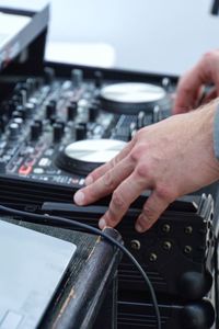 Cropped hands of man operating sound recording equipment