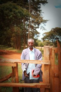 Portrait of man standing against trees