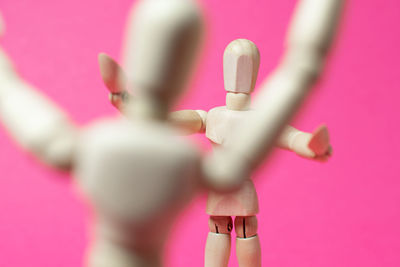 Close-up of figurine against pink background