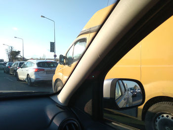 Cars on road against sky in city