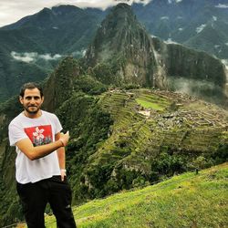 Portrait of young man standing on mountain