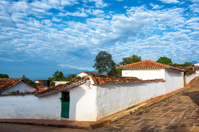 Houses in town against cloudy sky