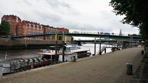 Bridge over river against sky in city