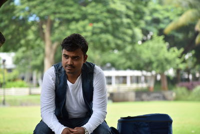 Thoughtful man sitting on bench at park