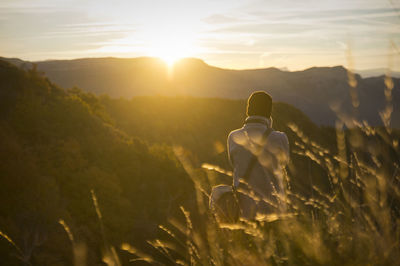 Rear view of man on mountain against sky