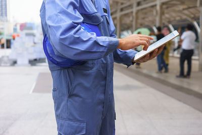 Midsection of man working with umbrella