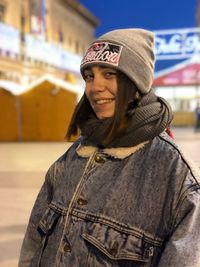 Portrait of smiling young woman standing outdoors in winter