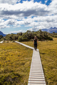 Rear view of woman on mountain against sky