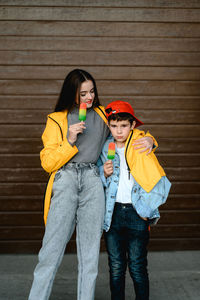 Portrait of smiling friends standing against wall