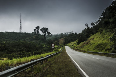 Empty road by mountain against sky