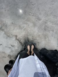 Low section of man standing on snow