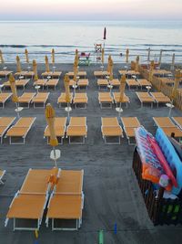 Chairs on beach against sky