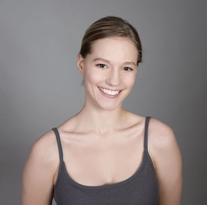 Portrait of beautiful young woman against gray background