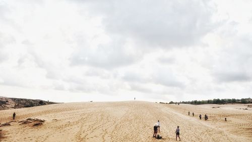 Rear view of people on land against sky