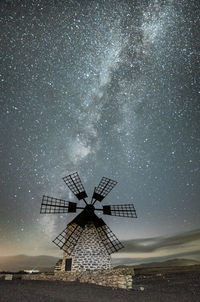 Traditional windmill against sky at night