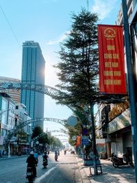 Information sign on city street against sky