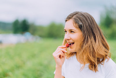 Happy farmer tasting red ripe strawberry at u-pick farm in washington