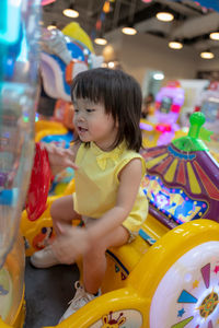 Smiling cute baby girl at amusement arcade