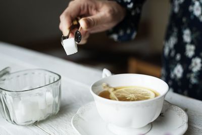 Midsection of man preparing food in cup on table