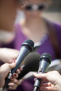 Cropped image of women holding microphones