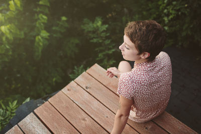 High angle view of thoughtful woman looking away while sitting on rooftop