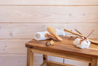 Spa items, rolled up towel, massage combs on wood background. eco-friendly products of organic beau