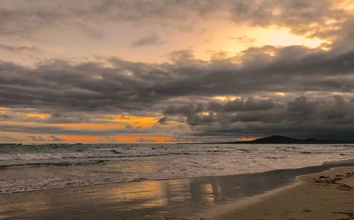 Scenic view of beach against dramatic sky