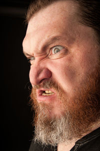 Close-up portrait of man against black background