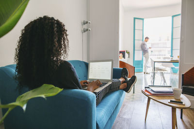 Rear view of woman using laptop
