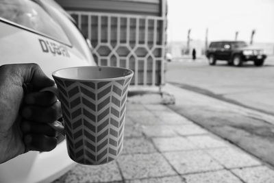 Close-up of hand holding coffee cup