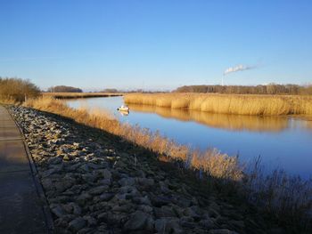 Scenic view of lake against clear blue sky