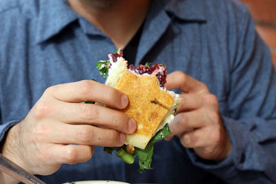 Midsection of man having sandwich