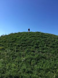 Low angle view of hill against clear blue sky