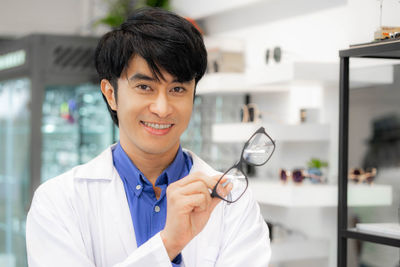 Portrait of female doctor holding dentures in laboratory