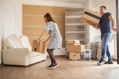 Rear view of woman with luggage walking on floor