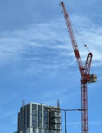 Low angle view of crane against sky