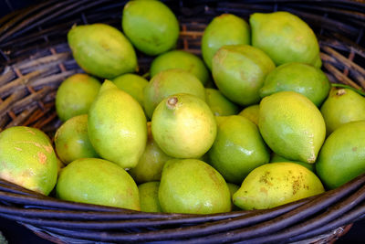 Close-up of lemons in basket at market for sale