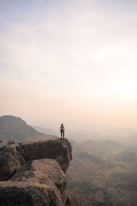 Man on rock against sky