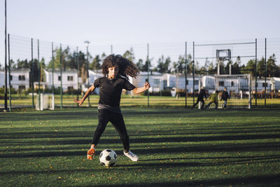 Female athlete playing soccer on sports field