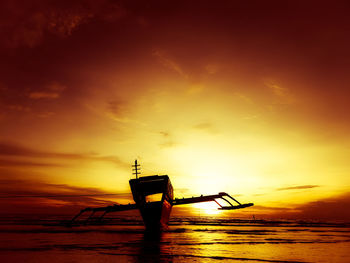 Silhouette ship in sea against sky during sunset