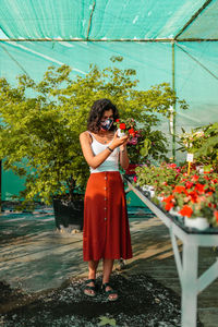 Woman standing by flowering plants